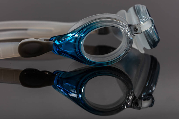 Gafas de natación (gafas de piscina) y reflexión sobre fondo negro
. - Foto, imagen