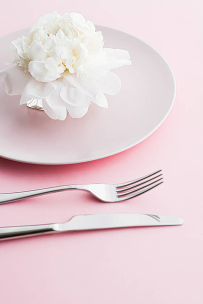 Piatto da pranzo e posate con fiore di peonia come decorazione di nozze set su sfondo rosa, stoviglie top per la decorazione di eventi e menu dessert
 - Foto, immagini