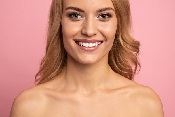 Close Up cropped half face portrait of attractive, nude, girl with healthy white teeth isolated on pink background, perfection, wellness, wellbeing, restoration concept. - Photo, Image