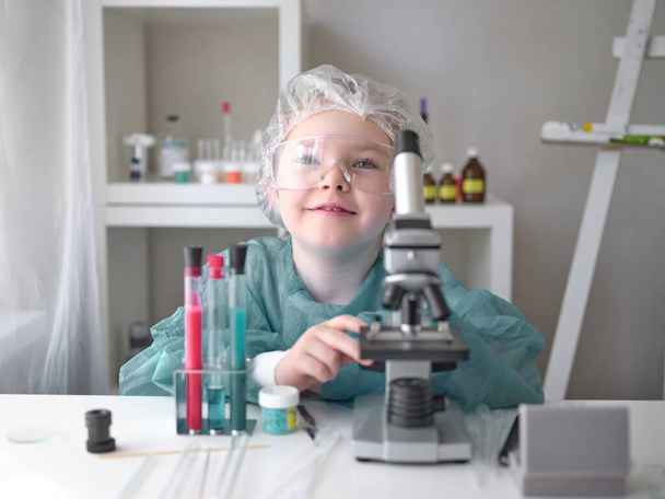 Mała dziewczynka pracuje naukowo w swoim domowym laboratorium. Koncepcja ta dotyczy dzieci przyszłości.. - Zdjęcie, obraz