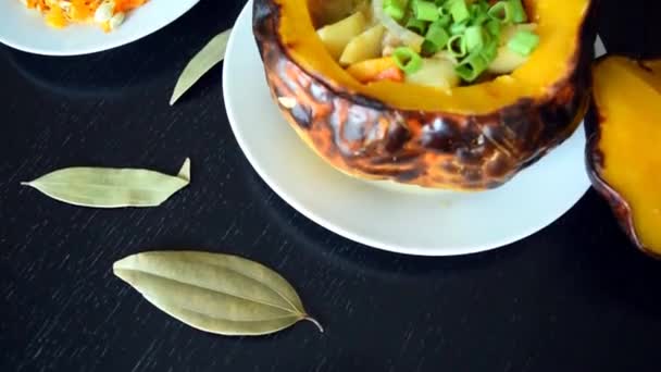 Baked pumpkin stuffed with meat and vegetables on a dark wooden background. Beef stew with vegetables in pumpkin. Baked pumpkin food  - Footage, Video