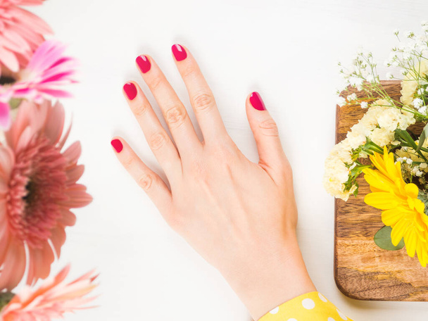 Mooie vrouwelijke hand met rode nagels op wit - Foto, afbeelding