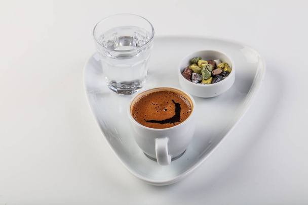 Café turco, chocolates dulces y agua en la mesa. Hermosa deliciosa bebida marrón tradicional sabrosa de la cultura turca. Disfruta de la foto conceptual
 - Foto, imagen