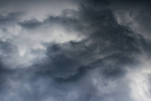 Bulutlu gökyüzünün bulanık görüntüsü. Mavi gökyüzü ve kara bulutlar. Renkli doğa arkaplanı. - Fotoğraf, Görsel