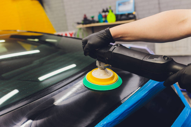 Car detailing - Hands with orbital polisher in auto repair shop. Selective focus. - Foto, Imagem
