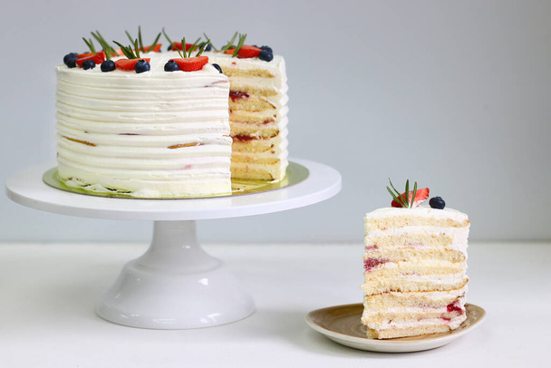 Crepe cake with strawberry blueberry and rosemary on light background. Crepes cake with cottage cheese and strawberry, selective focus - 写真・画像