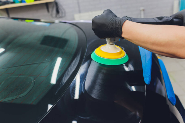 Car detailing - Hands with orbital polisher in auto repair shop. Selective focus. - Zdjęcie, obraz
