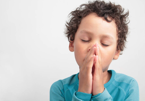 boy praying to god with hands together stock photo  - Fotó, kép
