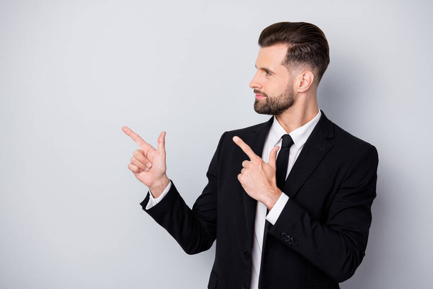 Profile side photo of successful smart company worker man point index finger copyspace present advertisement wear black formalwear outfit isolated grey color background - Foto, Imagem