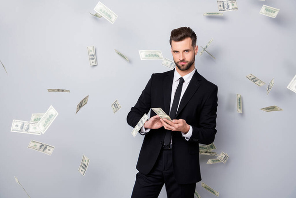 Portrait of smart confident rich company owner manager win lottery waste throw usd banknotes money fly fall wear black blazer tie jacket isolated over grey color background - Fotografie, Obrázek