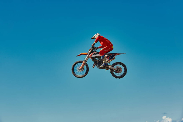 Motocross concept, a biker goes off-road making extreme skiing. In pursuit of adrinalin, sport concept. Dangerous sport. - Photo, Image