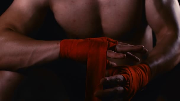 Мужчина боксер обертывает руки красной ручной пленкой перед тренировкой, 4k замедленной съемки
 - Кадры, видео