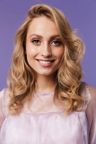 Image of happy caucasian woman smiling and looking at camera isolated over purple background - Foto, afbeelding