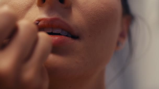Vista da vicino di un truccatore professionista che applica il rossetto sulle labbra del modello. 4k rallentatore - Filmati, video