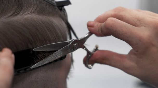 Peluquero profesional peinando y cortando el pelo del hombre
 - Foto, Imagen