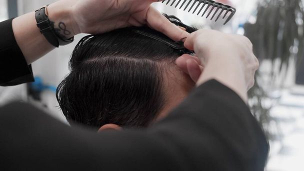 ВАРШАВА, ПОЛЬША - 30 июня 2019 года: Профессиональная женщина-парикмахер расчесывает волосы мужчин
 - Фото, изображение