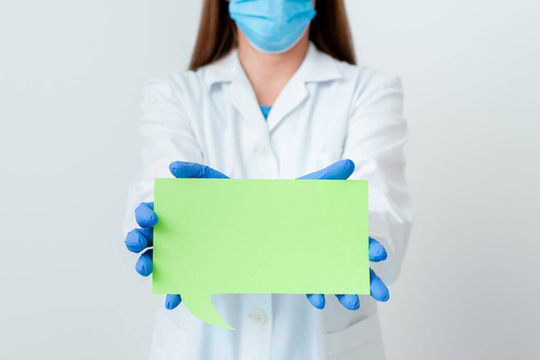 Henkilö yllään Medical Gown käsineet Kirurginen naamio eri kulma laukausta otettu tyhjällä tarra paperi tarvikkeet Moderni älypuhelin - Valokuva, kuva