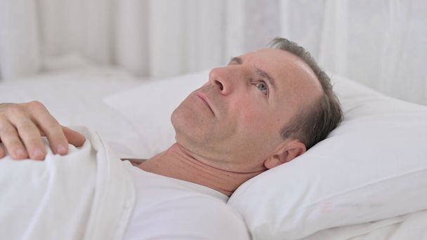 Töprengő középkorú férfi Ébredés az ágyban gondolkodás - Fotó, kép