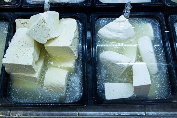 Шматочки білого сиру в солоній воді
 - Фото, зображення