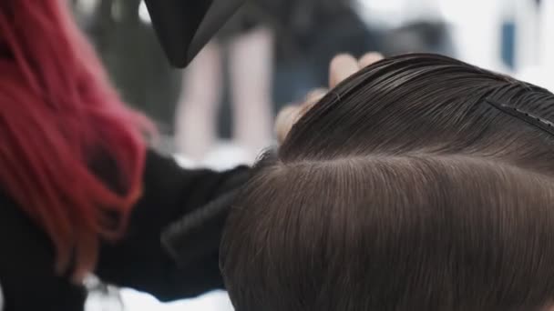 プロの女性のヘアスタイリストは、ヘアサロンで男性の髪を乾燥 - 映像、動画