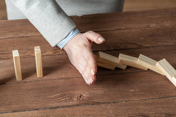 Business woman hand stop domino effect - Foto, immagini