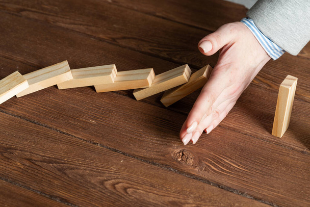 Business woman hand block domino effect - Foto, imagen