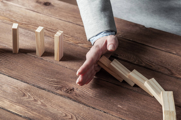 Business woman hand stop domino effect - Foto, Bild