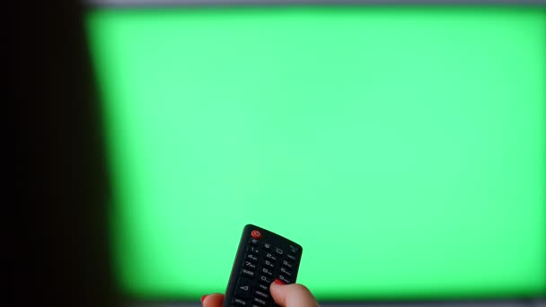 Frau mit Fernbedienung gegen Fernseher mit grünem Bildschirm, Standpunkt 4k - Filmmaterial, Video