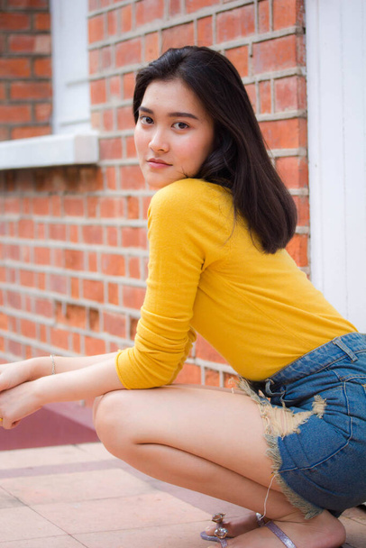 Portrait of thai Jeans skirt yellow shirt adult beautiful girl relax and smile - Zdjęcie, obraz