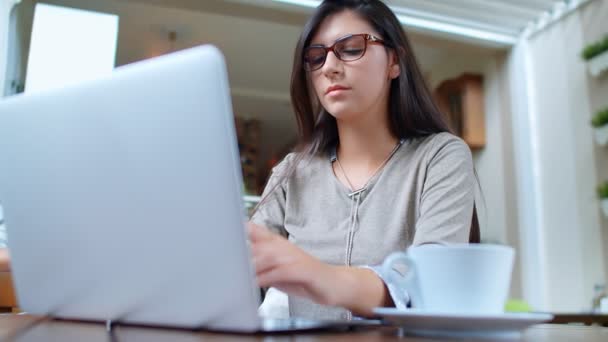 Όμορφη νεαρή επιτυχημένη επιχειρηματίας με φορητό υπολογιστή στο καφέ πίνοντας καφέ, εργάζονται σε φορητό υπολογιστή, και χρησιμοποιώντας το τηλέφωνο. - Πλάνα, βίντεο