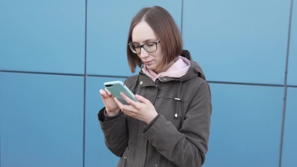 Houkutteleva valkoihoinen tyttö hipster opiskelija lasit älypuhelimella. - Materiaali, video