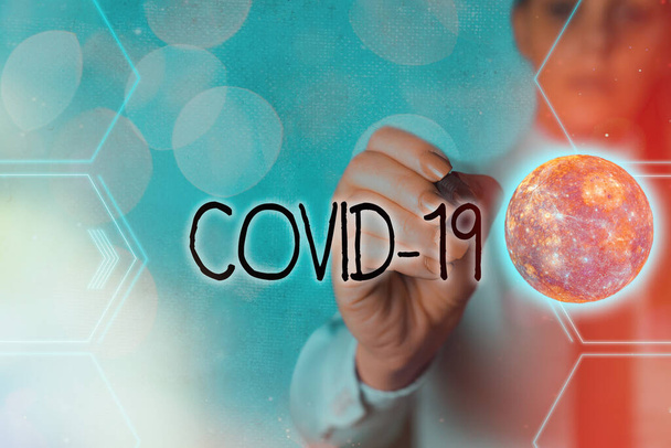 Χειρόγραφο κείμενο που γράφει Covid19. Έννοια που σημαίνει ήπια έως σοβαρή αναπνευστική ασθένεια που προκαλείται από ένα coronavirus φουτουριστικό εικονίδια ηλιακό σύστημα. Στοιχεία αυτής της εικόνας που παρέχονται από τη NASA. - Φωτογραφία, εικόνα