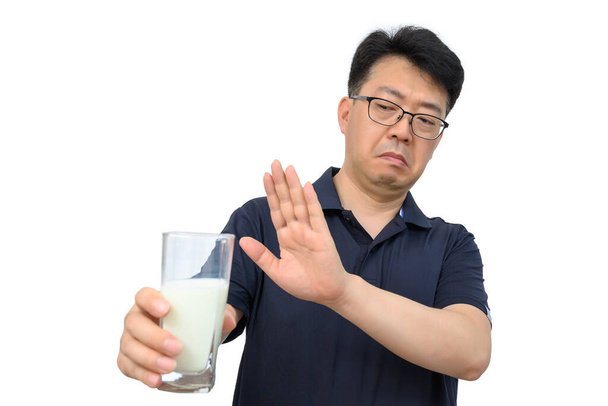 A middle-aged Asian male refusing milk. - Foto, afbeelding