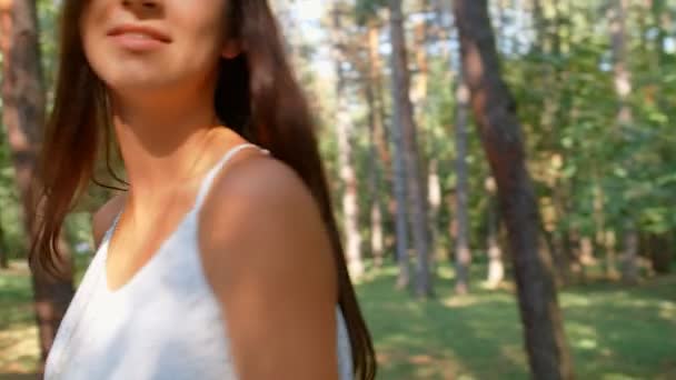 Portrait of beautiful brunette girl flirting with the camera in the park, 4k slow motion - Filmati, video