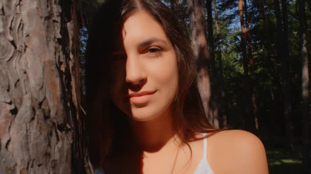Portrait of beautiful brunette girl flirting with the camera in the park, 4k slow motion - Felvétel, videó