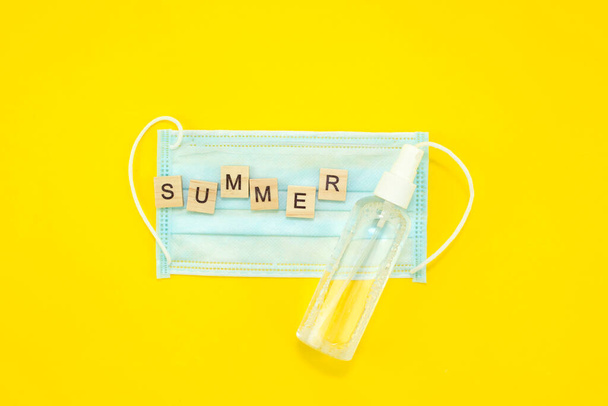 concept of summer 2020 and corona virus inscribed with the words summer on a medical mask, vacation and precautions - Photo, Image