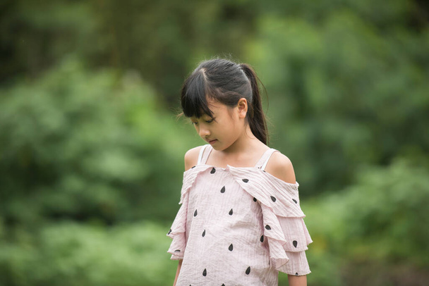 Портрет маленькой азиатки, гуляющей в парке
 - Фото, изображение
