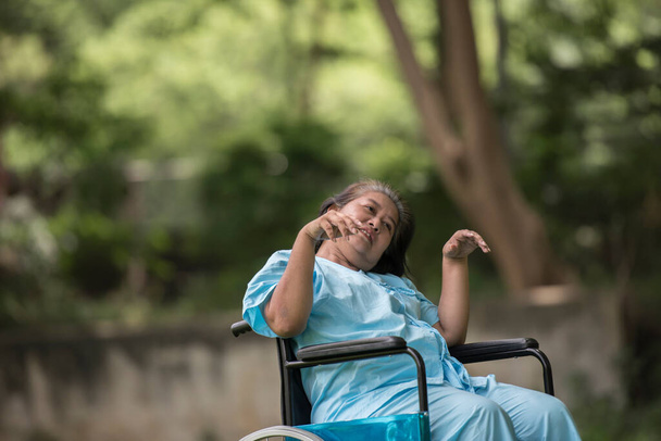 Пожилая женщина, сидящая на инвалидной коляске с болезнью Альцгеймера
 - Фото, изображение