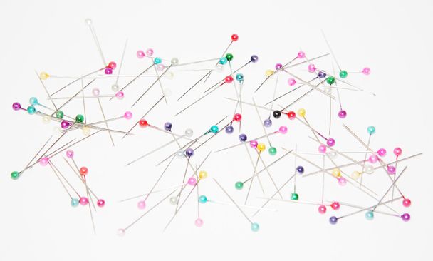 Safety pins with colored circular heads for sewing on white pape - 写真・画像