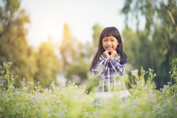 Happy little girl standing in the meadow - Fotografie, Obrázek