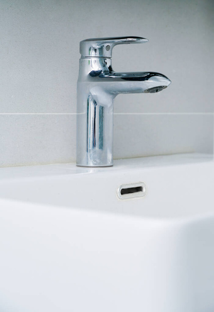 Handwaschbecken und Wasserhahn der minimalistischen Haushaltstoilette - Foto, Bild