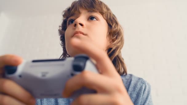 Een jonge pre-tiener jongen speelt video game console, veel plezier, lachen, houd de joystick, 4k pov - Video
