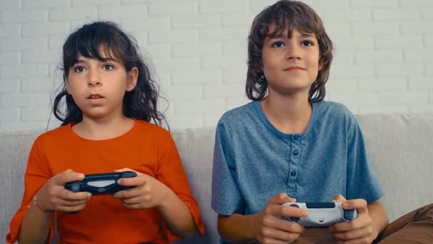Jonge pre-tiener jongen en meisje spelen video game console, veel plezier, lachen, houd de joystick, vieren overwinning, 4k - Video
