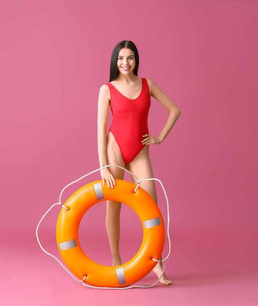 Beach rescuer with lifebuoy on color background - Foto, imagen