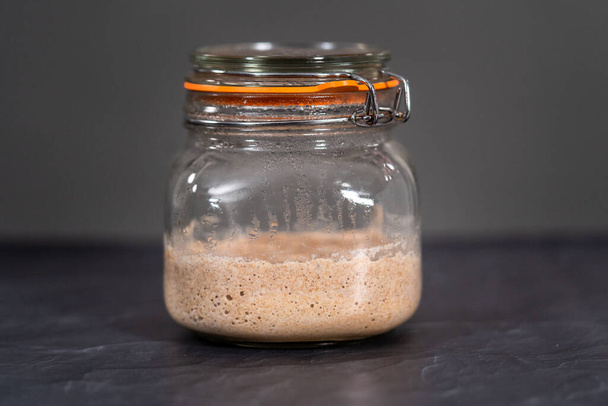 Entrante casero de masa madre de trigo en un frasco de albañil de vidrio. - Foto, Imagen