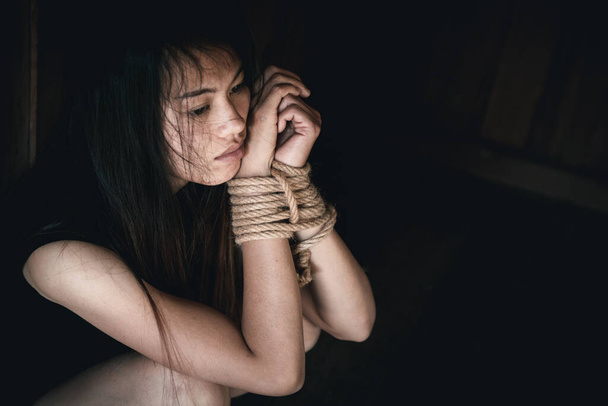 vítima mulher com as mãos amarradas com corda em estresse emocional e dor.Conceitos de violência contra as mulheres e tráfico de seres humanos, dia internacional da mulher
. - Foto, Imagem