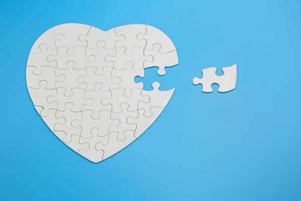 Unfinished white jigsaw puzzle pieces on blue background, The last piece of jigsaw puzzle, Copy space. - Photo, Image