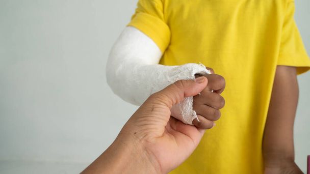Χαριτωμένο αγόρι χέρι κόκαλο σπασμένο από ατύχημα με νάρθηκα βραχίονα - Φωτογραφία, εικόνα