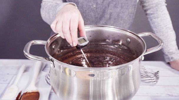 Passo dopo passo. Mescolare gli ingredienti nella pentola di cottura per fare semplice cioccolato fondente. - Foto, immagini