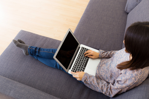 Frau benutzt Laptop auf Sofa - Foto, Bild